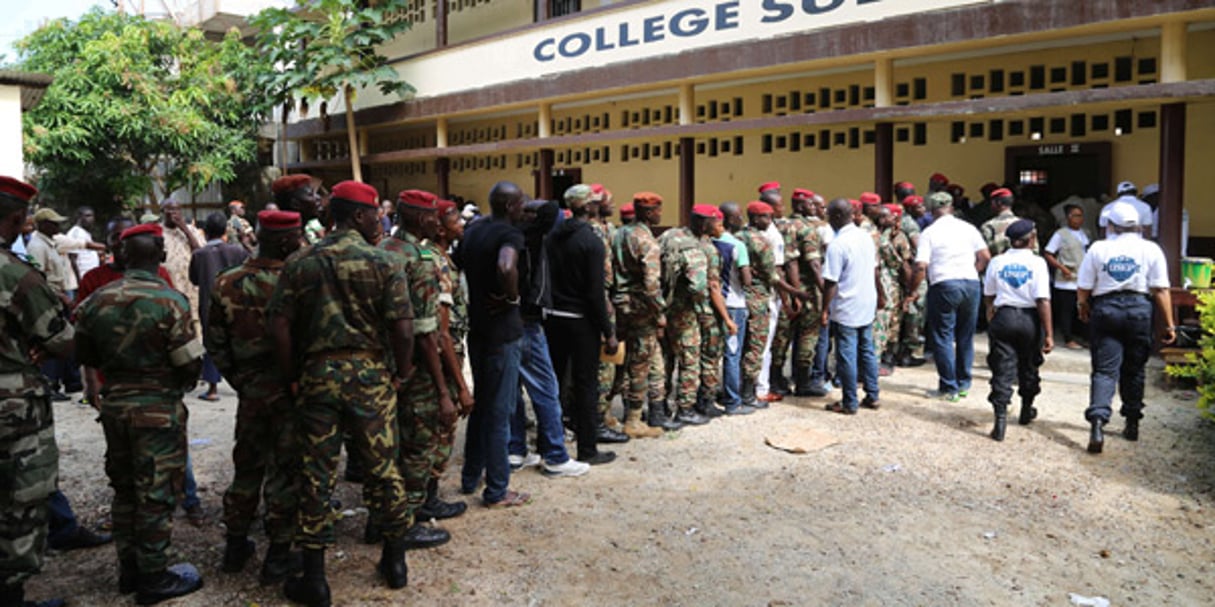 Des militaires guinéens font sagement la queue pour voter dans le quartier de Bambeto, à Conakry, le 11 juin 2015. © Youssouf Bah/AP/SIPA