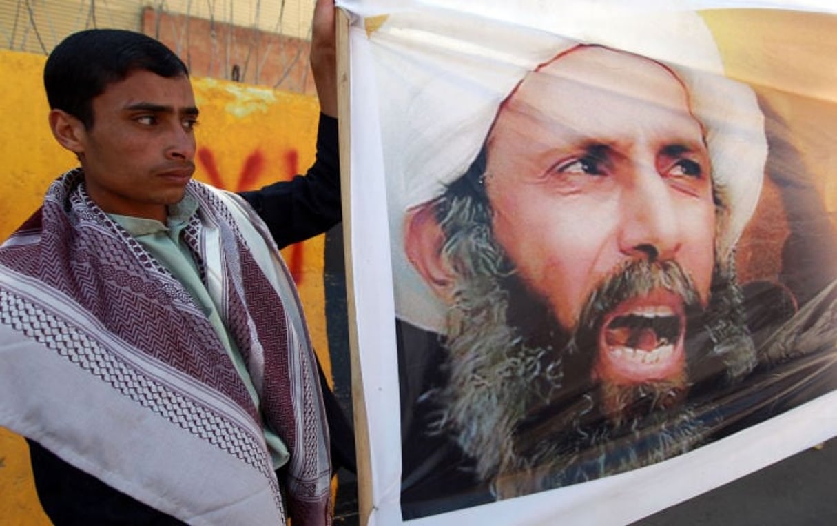 À Sanaa au Yémen, un manifestant arborant le portrait du dignitaire religieux chiite, Nimr Baqer al-Nimr en octobre 2014. © AFP