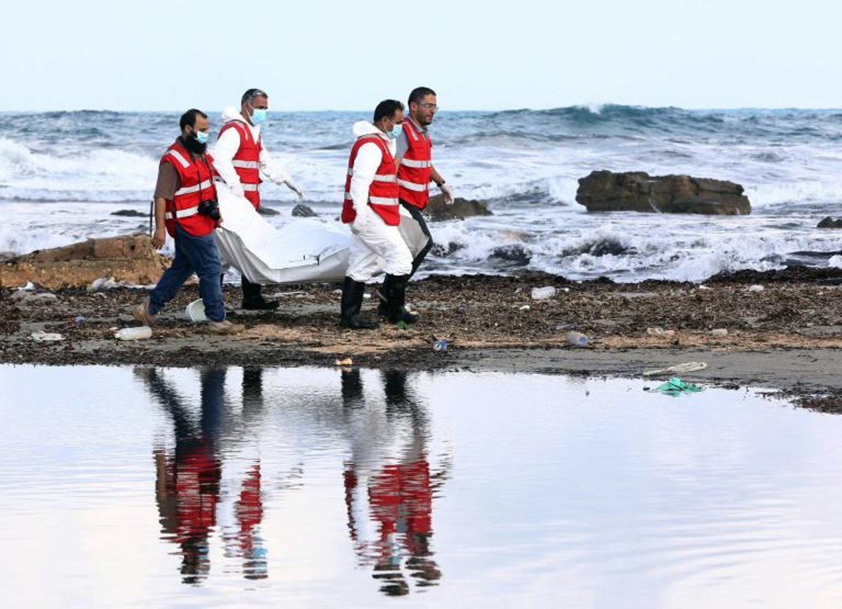 Des membres de la Croix-Rouge libyenne emmènent les cadavres de migrants découverts sur une plage, à l’est de Tripoli, le 25 octobre 2015. © AFP