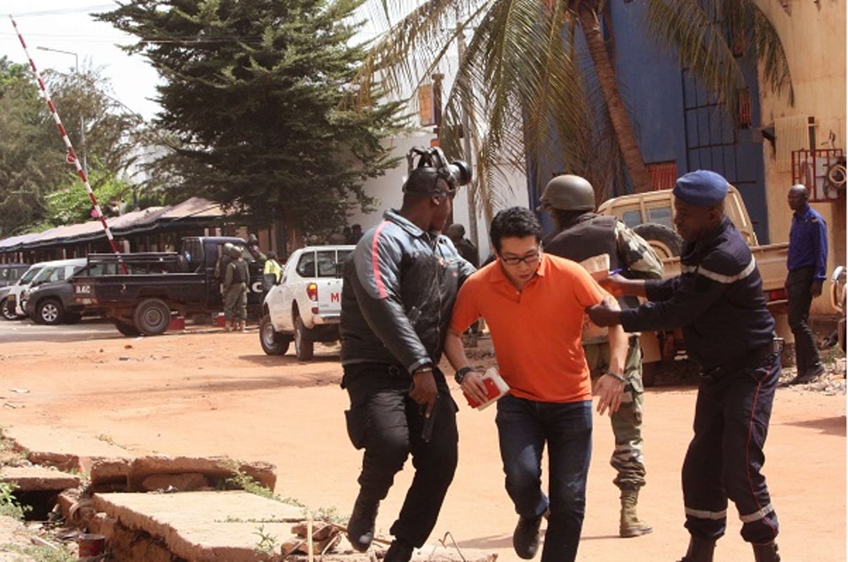 Des soldats maliens assistent l’un des otages évacués. © Harouna Traore/AP/SIPA