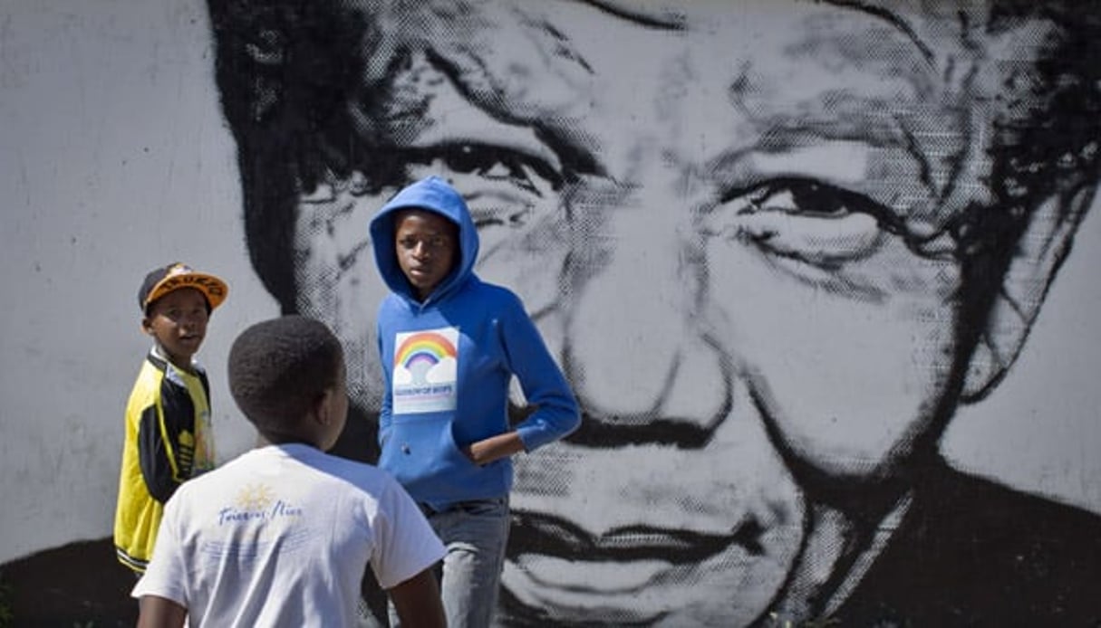 Des enfants sud-africains jouent devant une fresque murale représentant Nelson Mandela, le 2 mai 2014, dans le quartier Soweto de Johannesburg © Ben Curtis / AP / SIPA