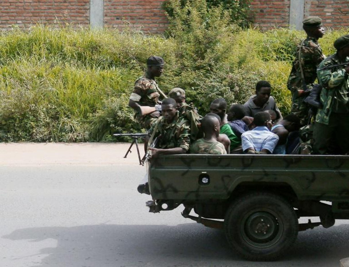 Un véhicule militaire transporte des hommes les mains liées, le 11 décembre 2015 à Burumbuja. © AFP