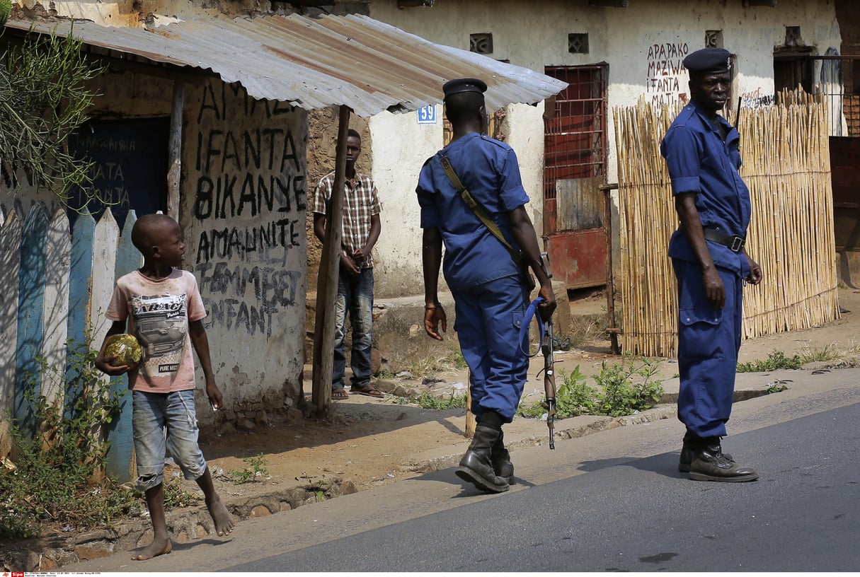 La police surveille la foule rassemblée pour les funérailles de Ndere Yimana, un opposant, assassiné la veille, le 22 juillet 2015, à Bujumbura, au Burundi. © Jerome Delay/AP/SIPA