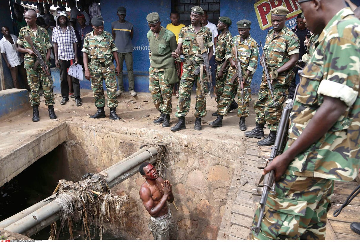 Un homme suspecté d’appartenir aux Imbonerakure supplie les militaires de le protéger de la foule (Bujumbura, le 7 mai 2015). © JEROME DELAY/AP/SIPA