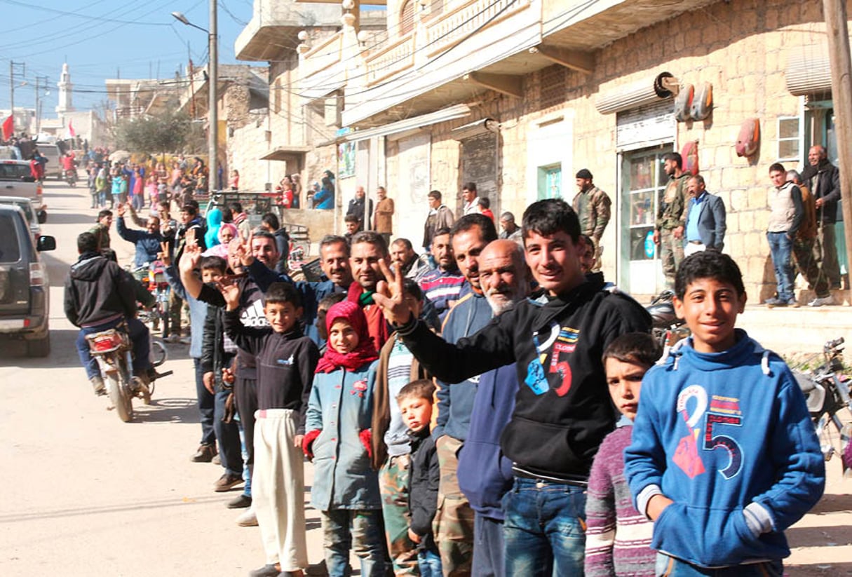 Des habitants de la ville chiite de Zahraa saluant les forces loyalistes, le 4 février. © AFP