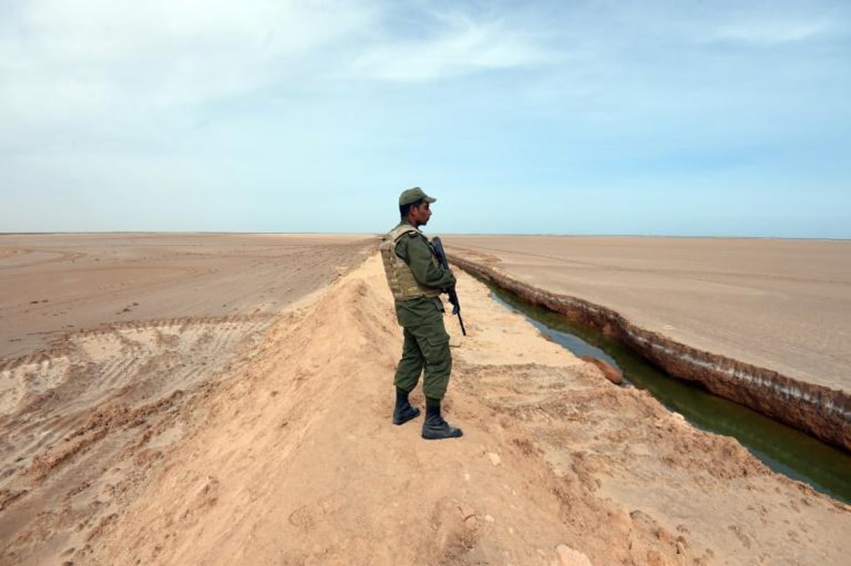 Un soldat tunisien se tient près d’une tranchée à la frontière libyenne, près du point de passage de Ras Jedir, le 6 février 2016. © AFP