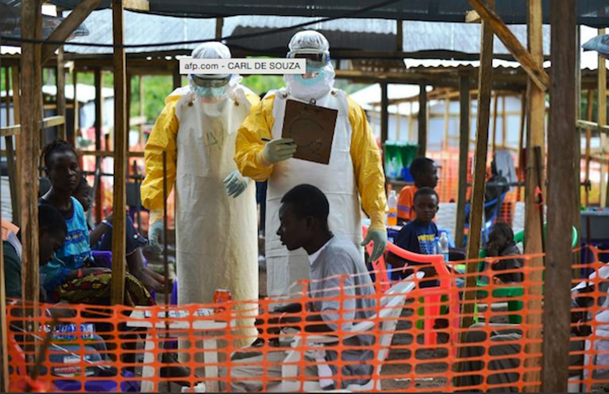 Un employé de MSF s’adresse à un patient dans une installation médicale à Kailahun, Sierra Leone, 15 août 2014 © Carlos De Souza / AFP