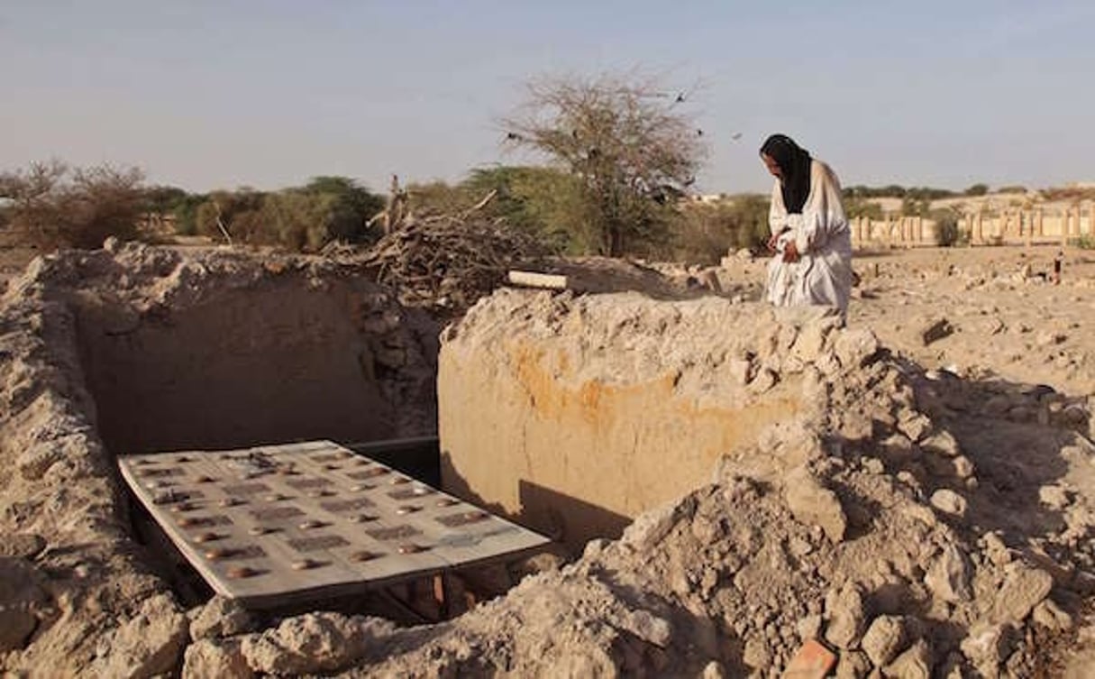 Mohamed Maouloud Ould Mohamed, chargé de l’entretien d’un mausolée de Tombouctou, se recueille le 4 avril 2014 sur l’une des tombes détruites par les terroristes. © Baba Ahmed / AP / SIPA