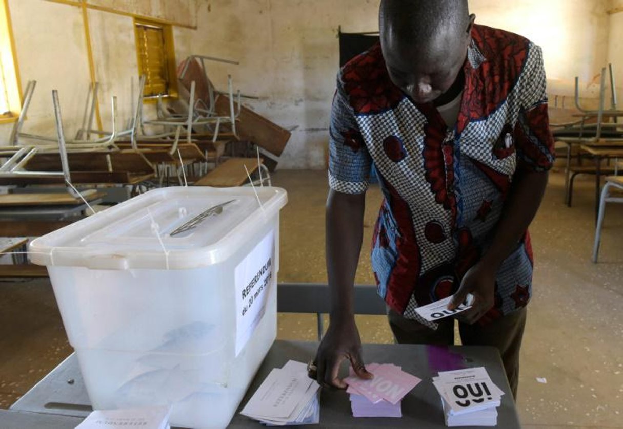 Un homme s’empare des bulletins de vote lors du référendum sur les réformes constitutionnelles à Fatick au Sénégal le 20 mars 2016. © Seyllou/AFP