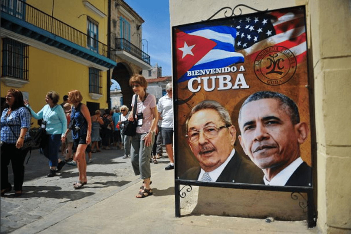 Des touristes se promènent près d’une affiche du président cubain Raul Castro et de son homologue américain Barack Obama à la Havane © Yamil Lage / AFP.com