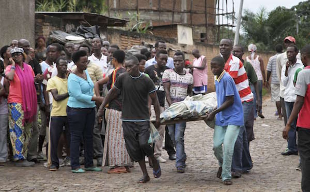 Des hommes transportent un corps, dans le quartier contestataire de Nyakabiga, dans l’est de Bujumbura, le 12 décembre 2015. © STR/AP/SIPA