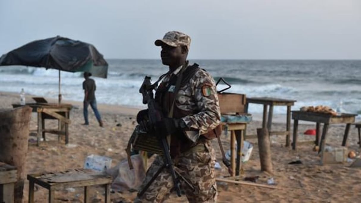 Un soldat ivoirien sur la plage de Grand Bassam après l’attaque. © AFP