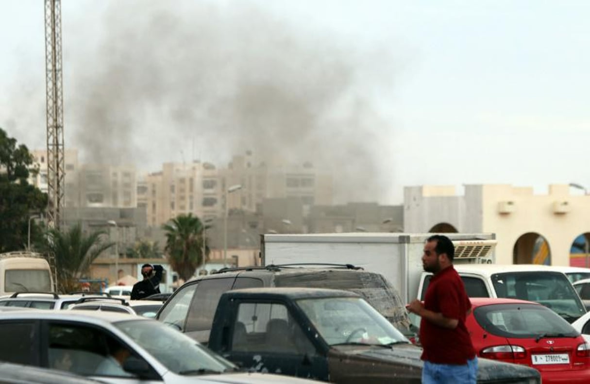 Des manifestants courent pour échapper à des bombardements lors d’un rassemblement sur la place el-Kich à Benghazi le 6 mai 2016, en soutien aux forces armées loyales au Parlement reconnu installé à Tobrouk, dans l’est du pays. © AFP