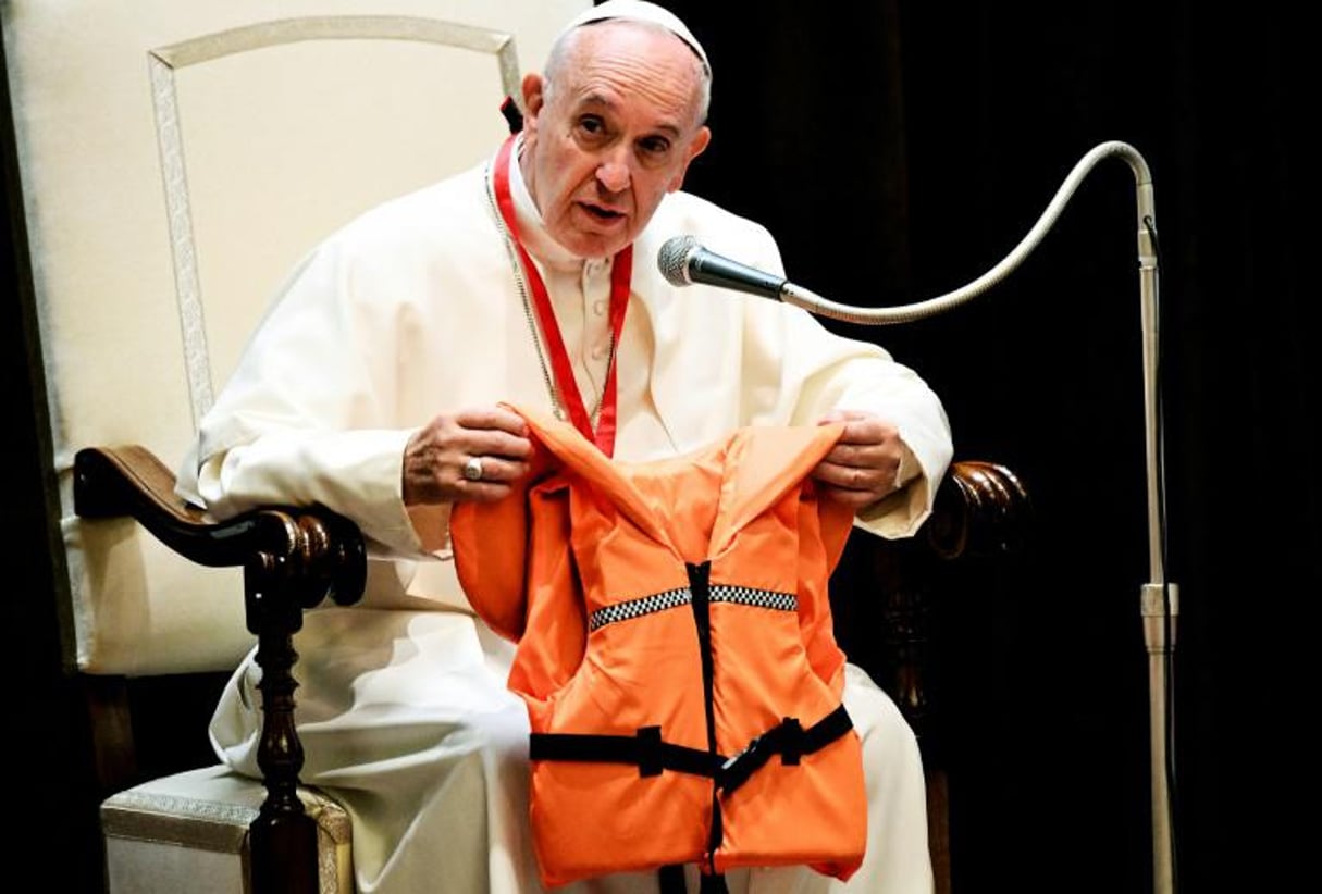 Le pape François montre lors d’une réunion avec des jeunes, le 28 mai 2016 au Vatican, le gilet de sauvetage d’un jeune qui s’est noyé en Méditerranée en essayant de rejoindre l’Europe. © AFP