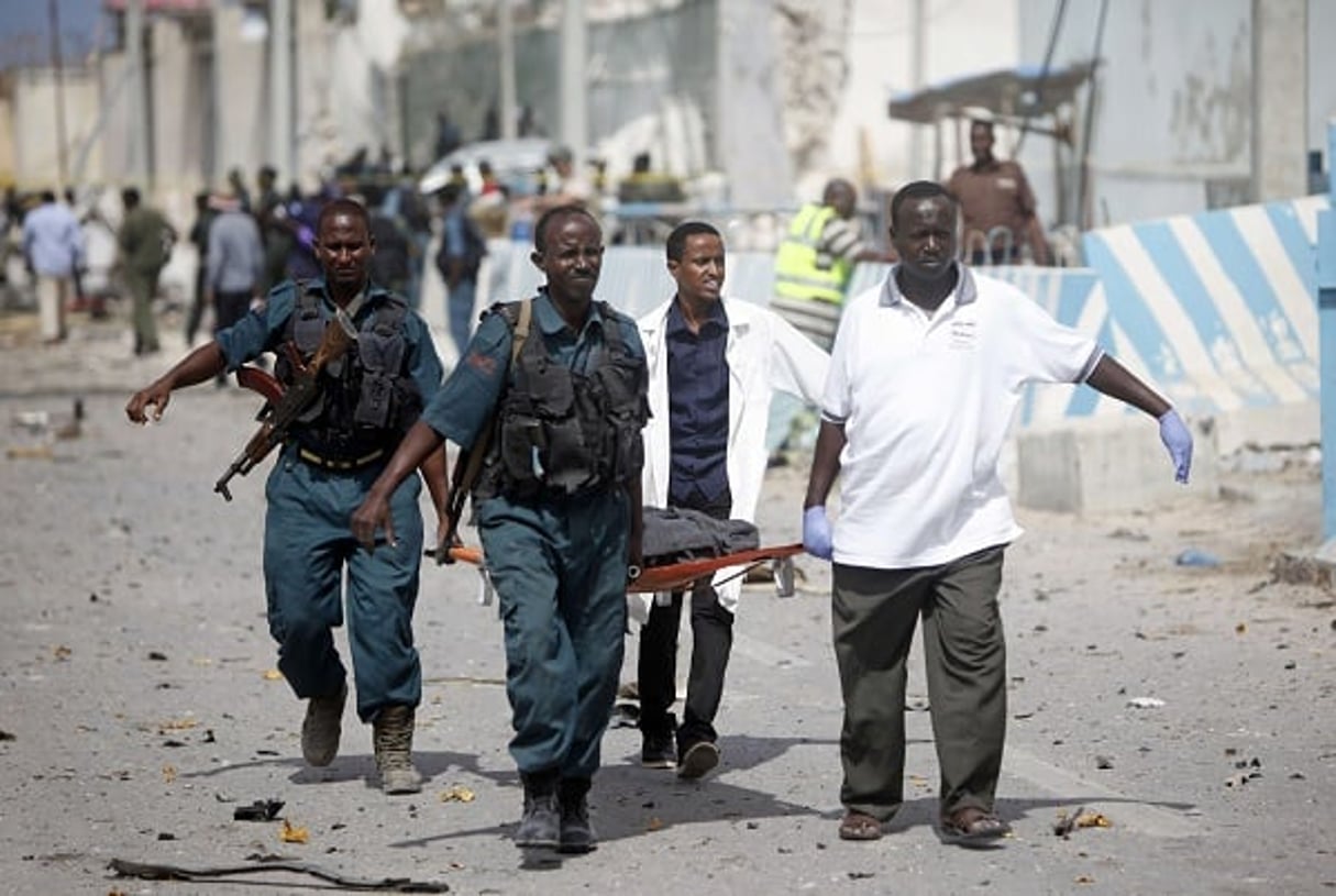 Des gardes des bureaux des Nations unies et des soldats somaliens portent le corps d’un de leurs collègues après une attaque à Mogadiscio, le  26 juillet 2016. © Farah Abdi Warsameh/AP/SIPA