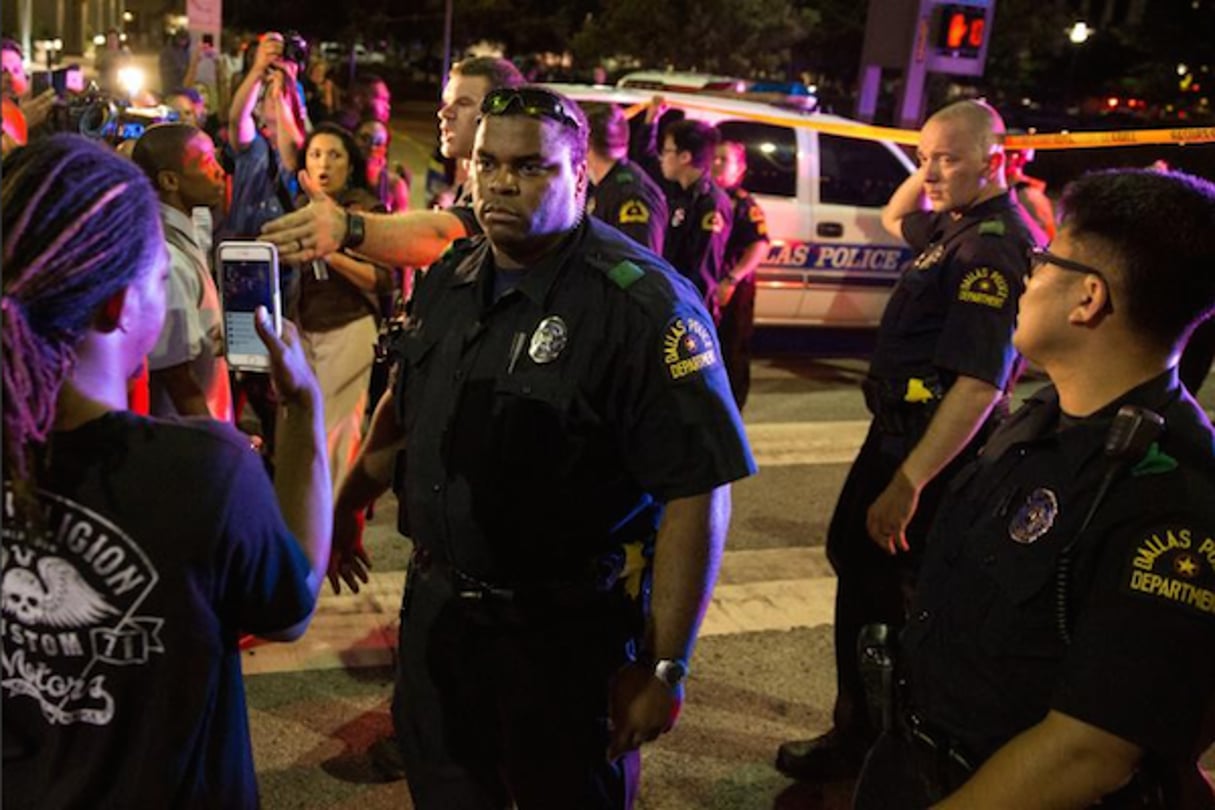 Des policiers au milieu de manifestants après l’arrestation de suspects le 7 juillet 2016 à Dallas. © AFP