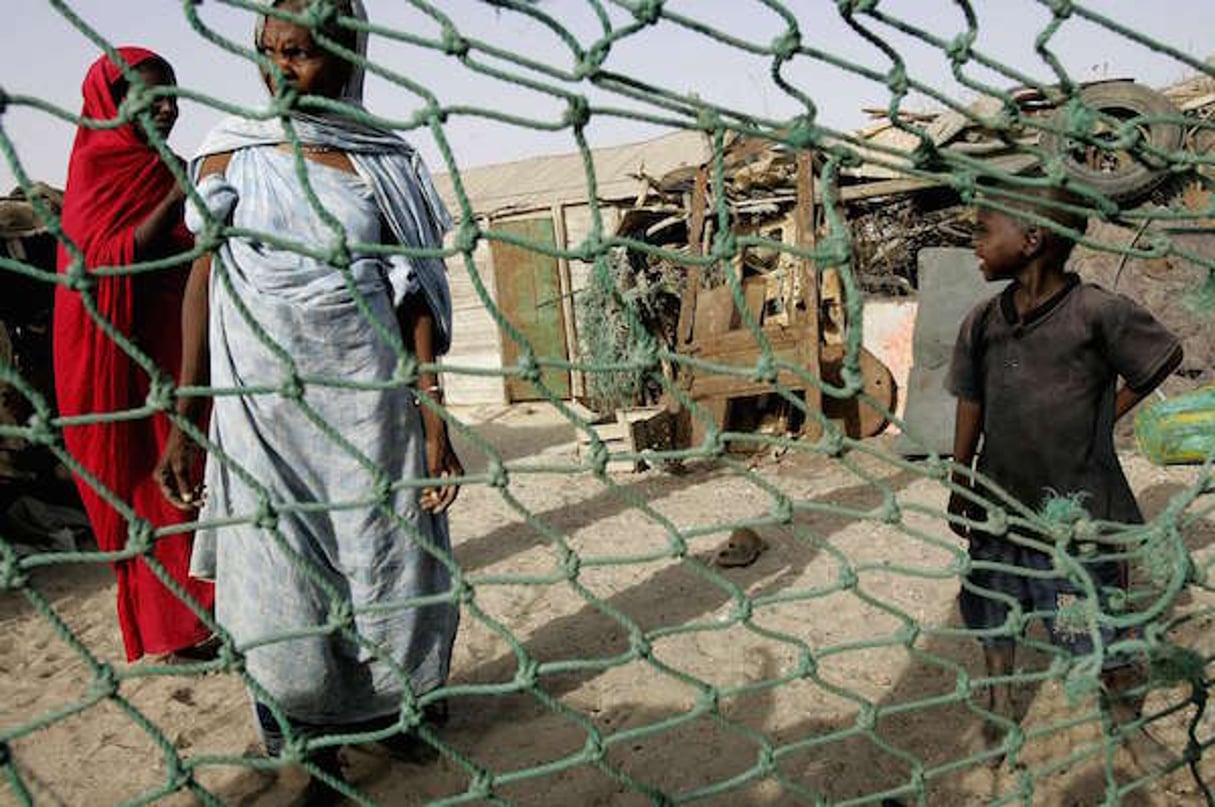 Personnes devant leur maison dans un quartier pauvre de Nouakchott, le 26 juin 2006. © SCHALK VAN ZUYDAM/AP/SIPA
