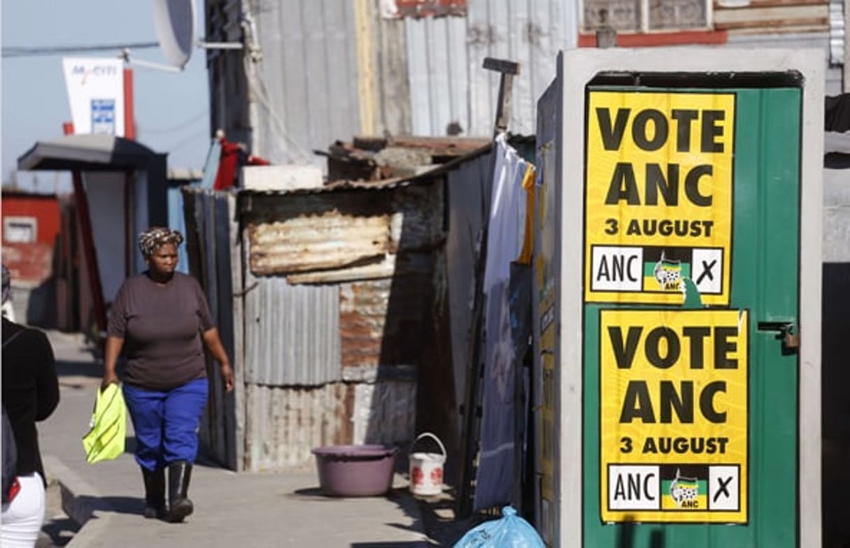 Une femme se promenant à côté d’une affiche politique appelant à voter pour l’ANC dans le township de Khayelitsha à la périphérie du Cap, le 1er août 2016. © Schalk van Zuydam/AP/SIPA
