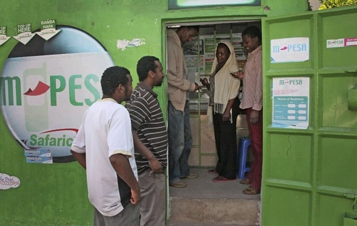 Des clients attendent devant un comptoir M-Pesa à Nairobi, en août 2011. © Sayyid Abdul Azim/AP/SIPA