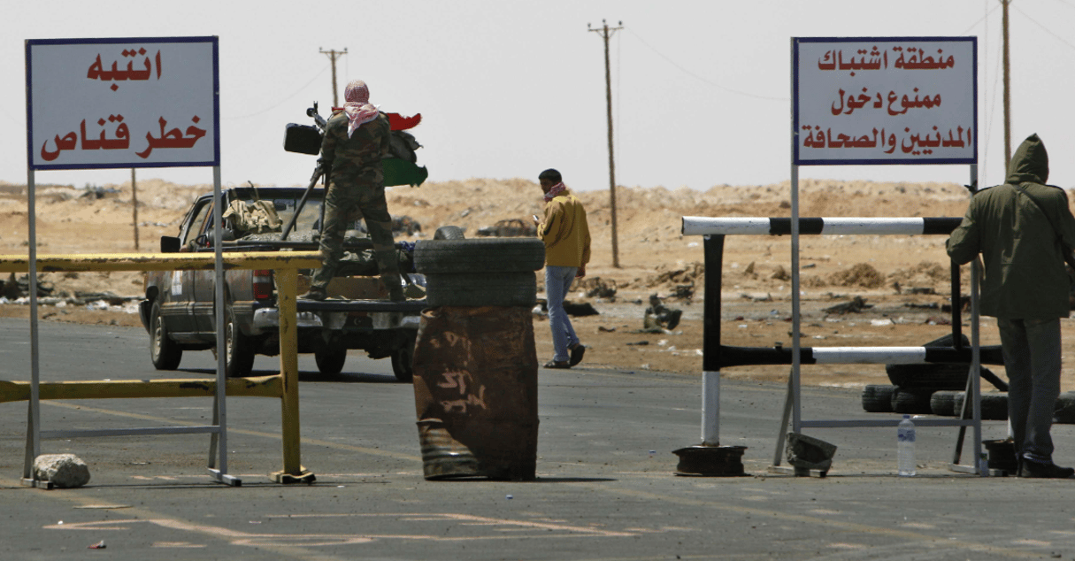 Des rebelles libyens bloquant l’entrée d’Ajdabiya avec un panneau « zone de guerre, interdit aux citoyens et journalistes », le 23 avril 2011 © Nasser Nasser/AP/SIPA
