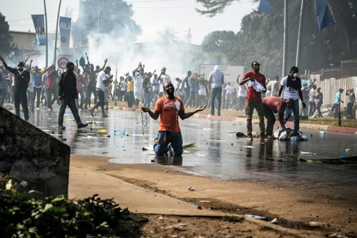 Un partisan de l’opposition gabonaise prie devant les forces de l’ordre à Libreville lors d’une manifestation de l’opposition contre la réélection d’Ali Bongo, le 31 août 2016. © Marco Longari /AFP