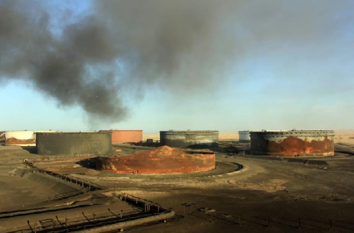 De la fumée s’échappe de terminaux de stockage pétroliers en Libye après des combats, le 9 janvier 2016 près de Ras Lanouf. © STRINGER/AFP