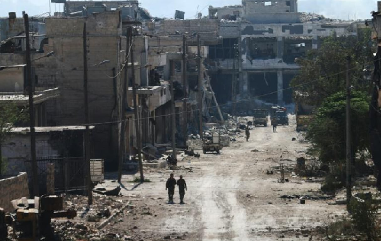 Des combattants syriens pro-régime empruntent une rue de la ville d’Alep ravagée par les bombardements, le 9 septembre 2016. © GEORGE OURFALIAN/AFP