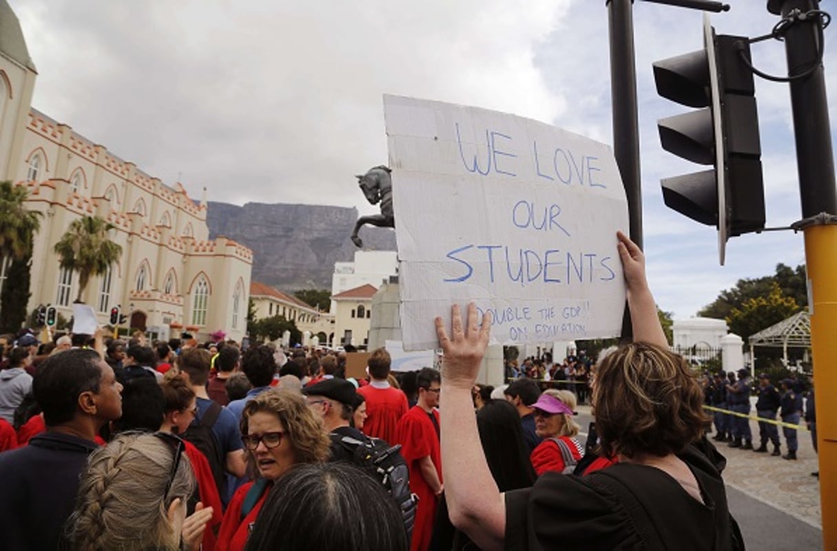 Une femme brandissant une pancarte indiquant « nous aimons nos étudiants » lors d’une manifestation contre la hausse des frais de scolarité à Cape Town devant le parlement sud-africain le 22 septembre 2016. © Schalk van Zuydam/AP/SIPA