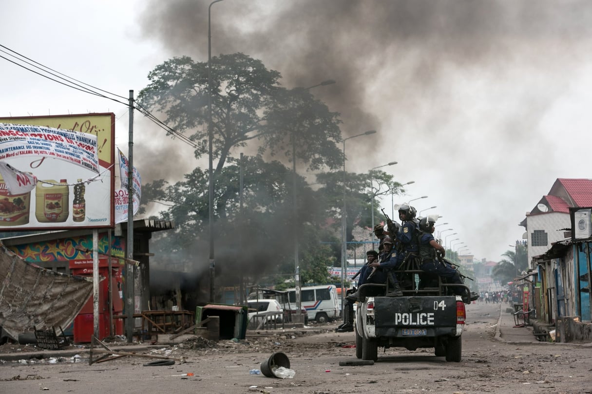 Patrouille de police à Kinshasa, devant le commissariat de la commune de Kalamu, incendié par des manifestants le 20 septembre 2016. © Gwenn Dubourthoumieu pour JA