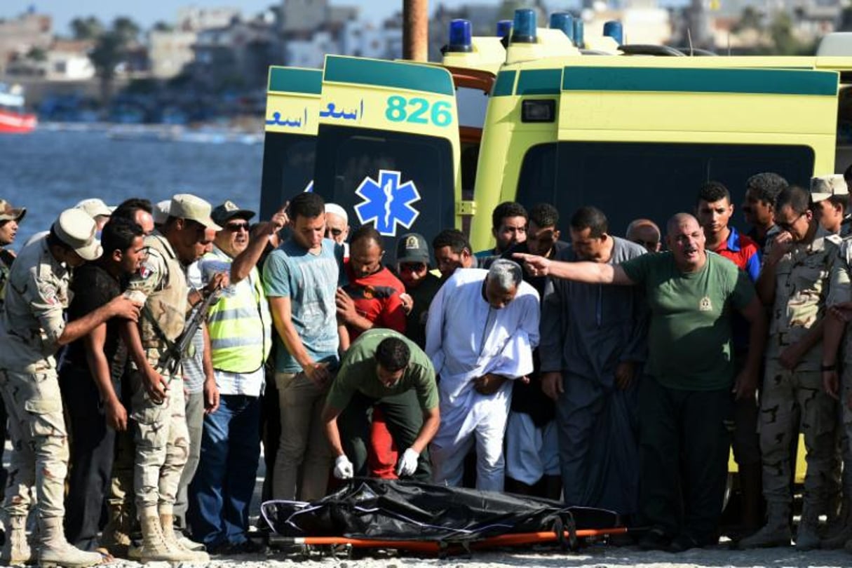 Des personnels médicaux recouvrent le corps d’un migrant décédé dans le naufrage d’un bateau, le 22 septembre 2016 dans le port de Rosette, en Égypte. © Mohamed el-Shahed/AFP
