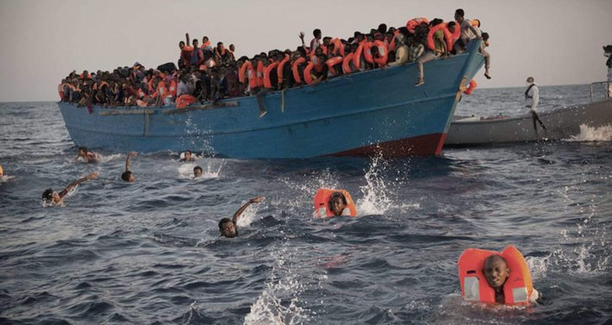 Migrants, most of them from Eritrea, jump into the water from a crowded wooden boat as they are helped by members of an NGO during a rescue operation at the Mediterranean sea, about 13 miles north of Sabratha, Libya. © Emilio Morenatti/AP/SIPA