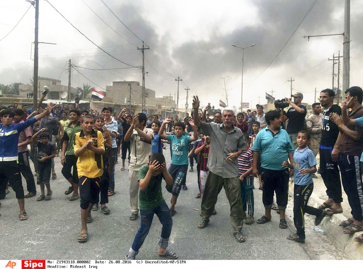 Des habitants de Qayyarah, à 70 km au sud de Mossoul, célébrant la libération de la ville, le 26 août. © AP/SIPA