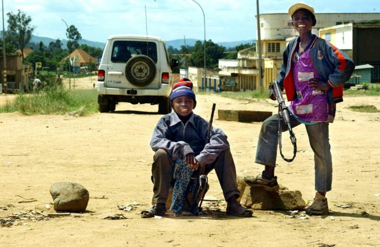 Deux enfants soldats dans une rue de Bunia, dans le nord-est de la RDC, le 15 mai 2003. © Marco Longari/AFP