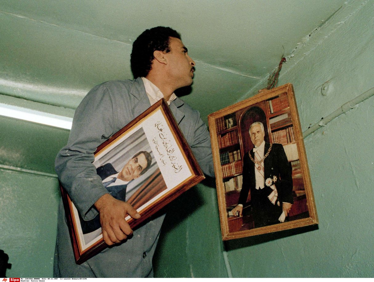 Changement de portrait présidentiel le 9 novembre 1987 dans un commerce de Tunis. A gauche, le nouveau président Zine el Abidine Ben Ali et à droite Habib Bourguiba. © Laurent Rebours/AP/SIPA