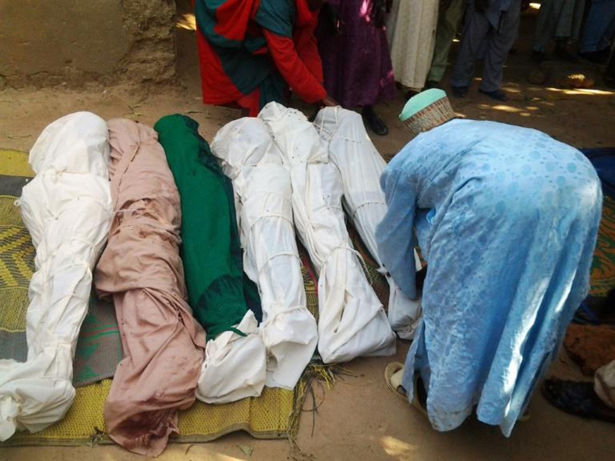 Un habitant enveloppe des cadavres dans des linceuls après une attaque de bandits dans la province de Zamfara au Nigeria, le 18 juin 2013. © AFP