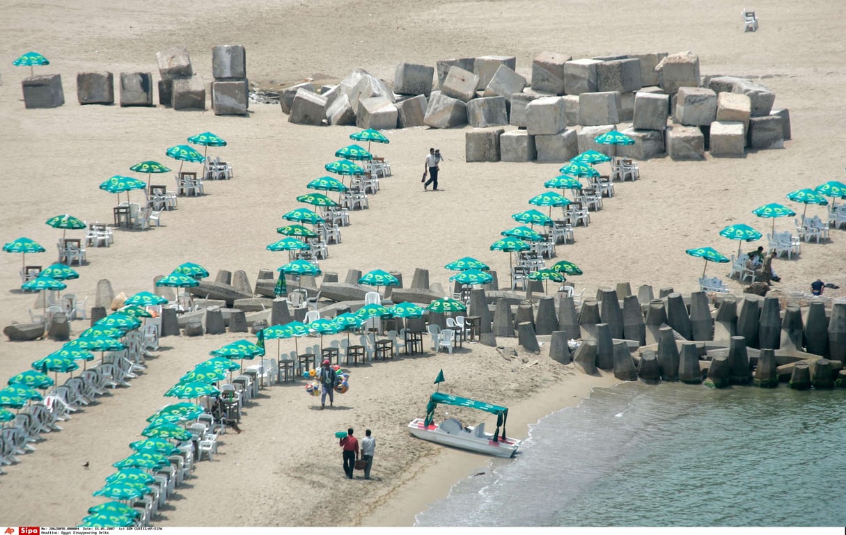 Des blocs de béton utilisés contre la montée des eaux posés à côté des parasols sur une plage d’Alexandrie le 15 mai 2007. © BEN CURTIS/AP/SIPA