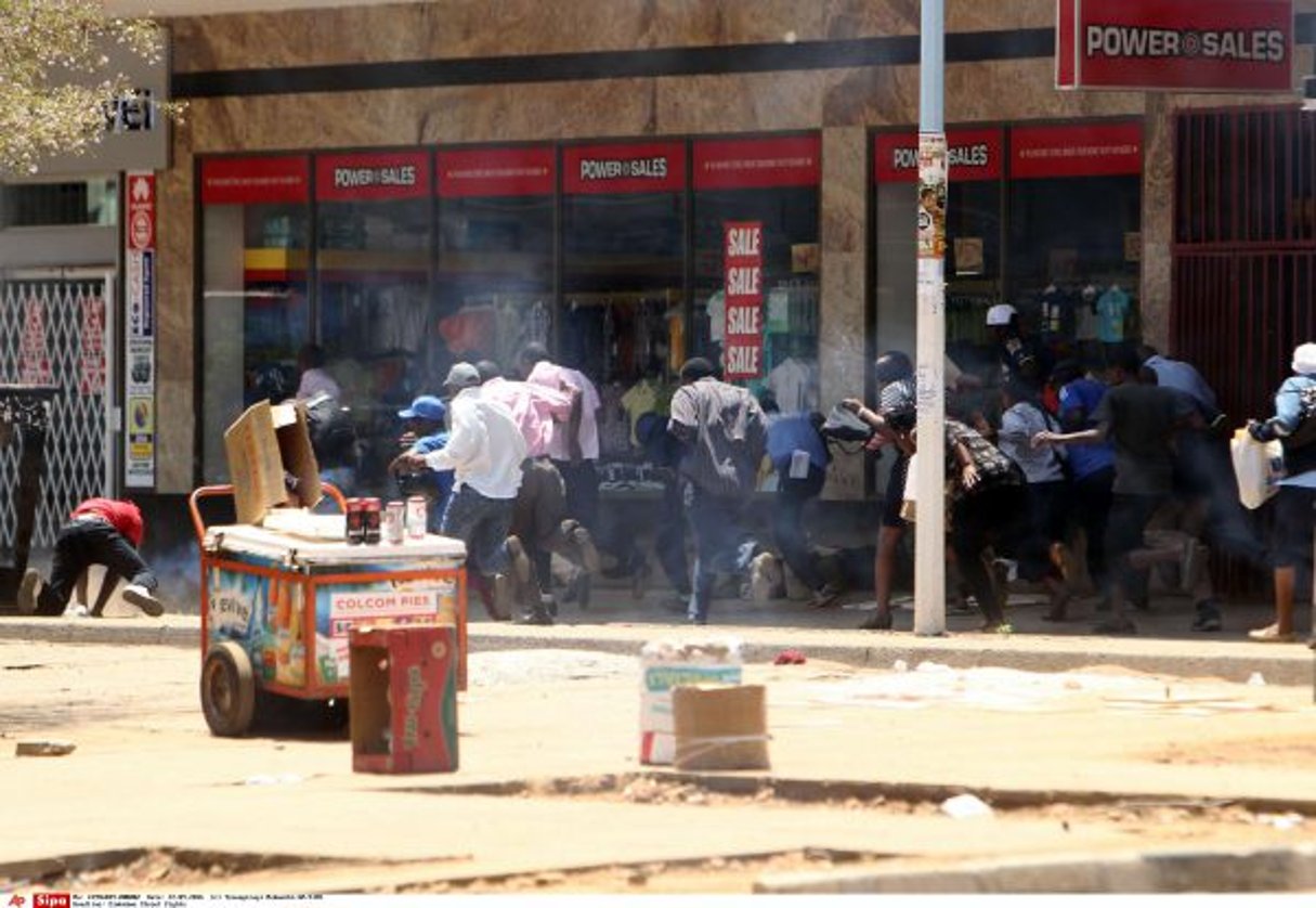 La foule court se cacher pour échapper aux affrontements entre manifestants et police anti-émeute le 27 septembre 2016 à Harare. © Tsvangirayi Mukwazhi/AP/SIPA