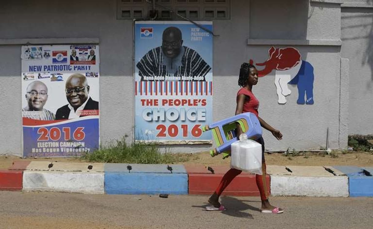 A Accra, une femme pose des affiches de campagne d’un des candidats à l’élection présidentielle ghanéenne du 8 décembre 2016, Nana Akufo-Addo. © Sunday Alamba/AP/SIPA