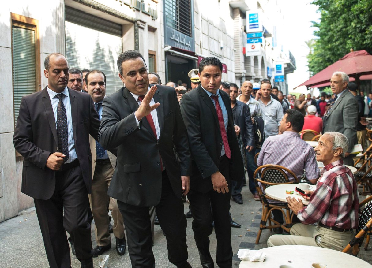 Mehdi Jomâa saluant des concitoyens attablés à une terrasse de café, avenue Habib-Bourguiba, à Tunis, le 26 octobre 2014. © Ahmet Izgi/Anadolu agency/AFP