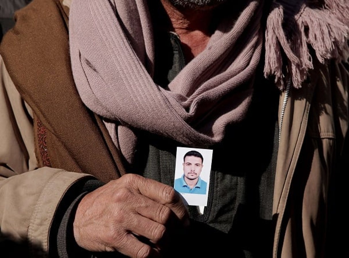 Un père montre le portrait de l’un de ses fils tués en Libye en 2014. © Nariman El-Mofty/AP/SIPA