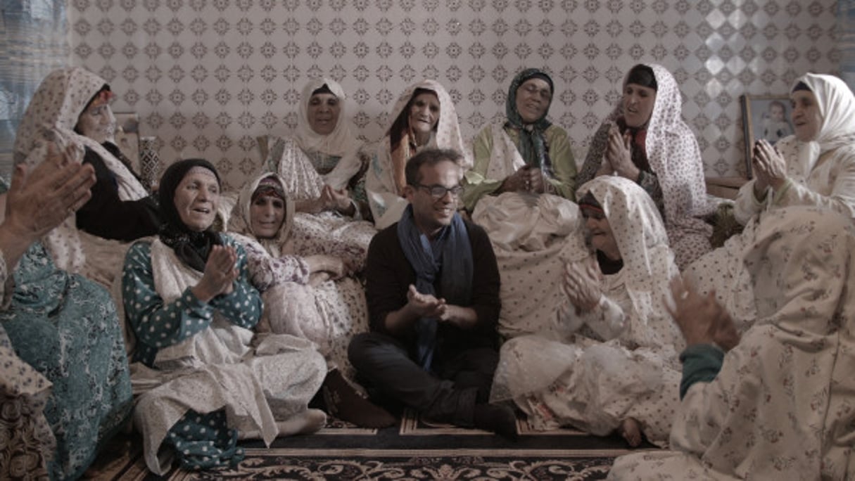 Au milieu des vieilles femmes du village de Tinghir, le réalisateur Kamal Hachkar déclame des chansons amazighs. © Zakaria Ait Wakrim