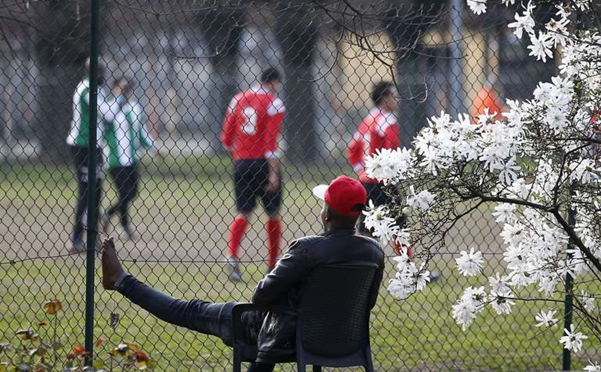 Un demandeur d’asile regarde un match de football, à Milan, le 18 mars 2017. © Antonio Calanni/AP/SIPA