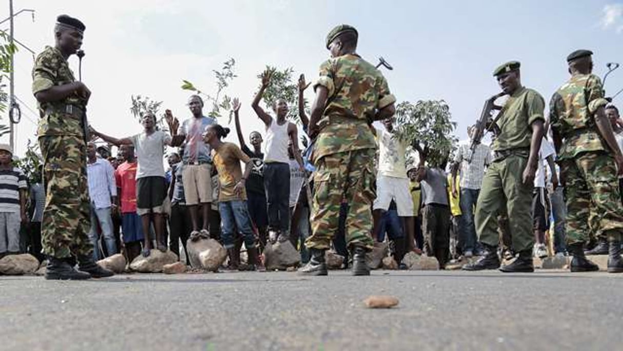 Des manifestants burundais brandissent des branches en signe de paix face à des soldats, à Bujumbura le 27 mais 2015. © Gildas Ngingo/AP/SIPA
