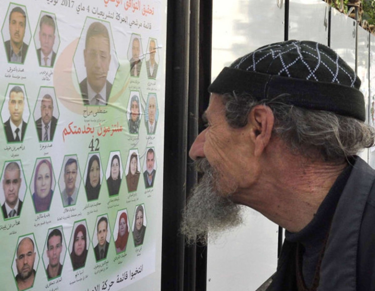 Un homme scrutant une affiche électorale  à Alger le 9 avril 2017. © Anis Belghoul/AP/SIPA