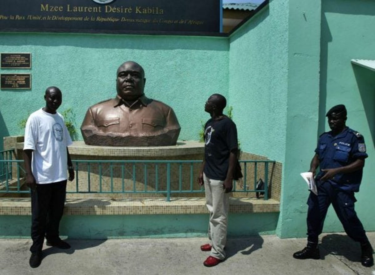 Des Congolais posent devant le buste de Laurent-Désiré Kabila, le 17 mai 2005, à Kinshasa. © Schalk Van Zuydam/AP/SIPA