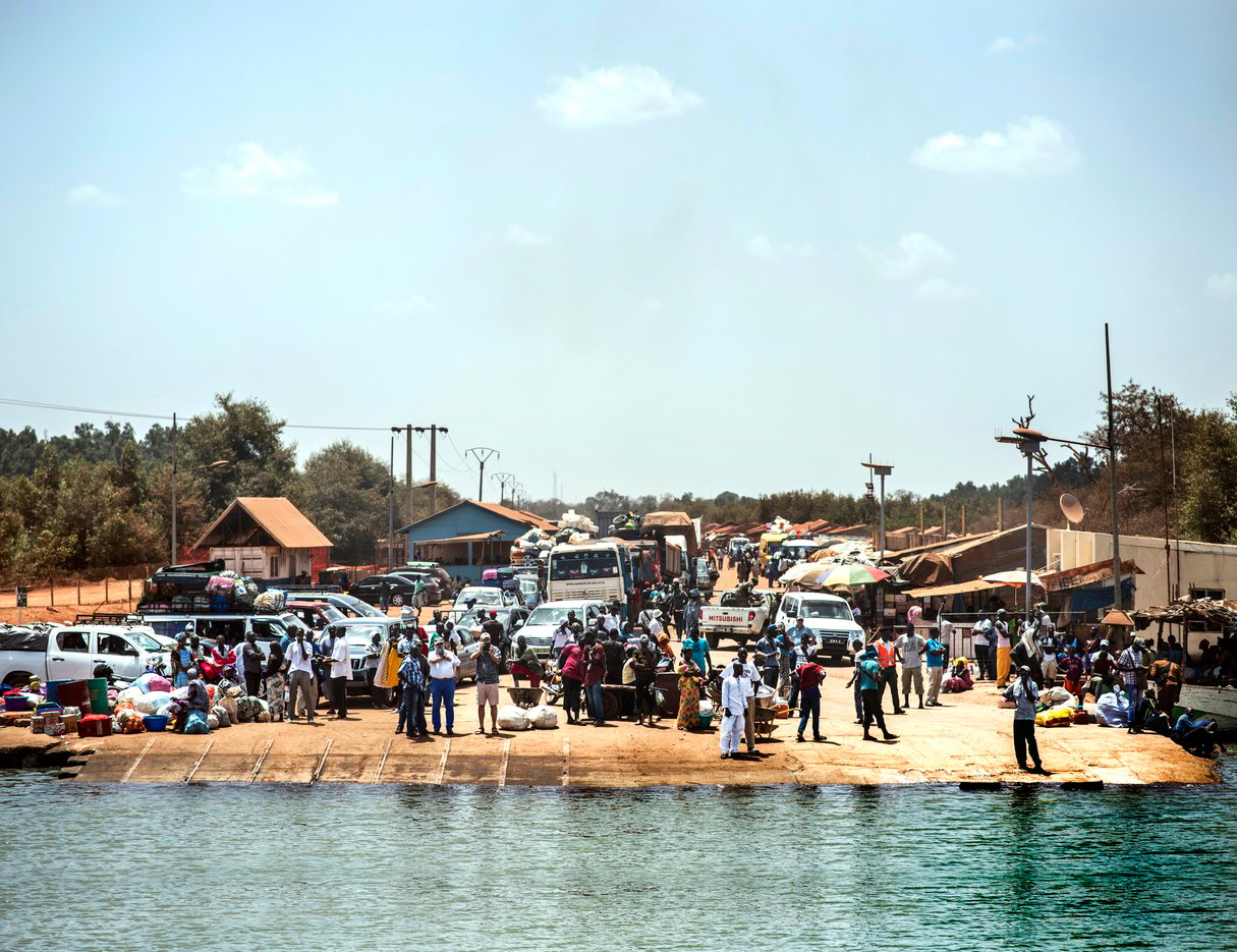 À Farafenni, en Gambie, des voyageurs attendent le bac pour traverser le fleuve et rejoindre le sud du Sénégal. © Sylvain Cherkaoui pour JA