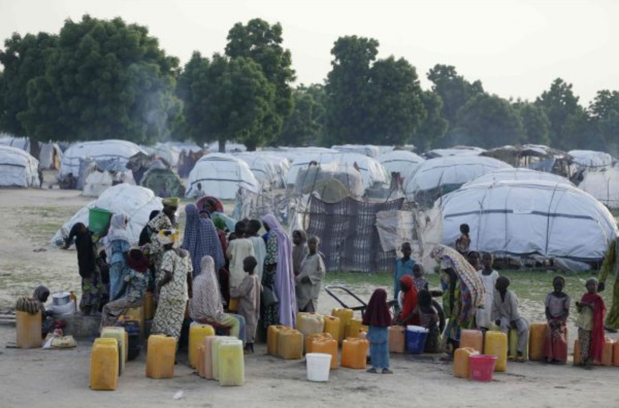 Des Nigérians déplacés par les attaques de Boko Haram attendent une distribution d’eau dans un camp près de Maiduguri en août 2016. © Sunday Alamba/AP/SIPA