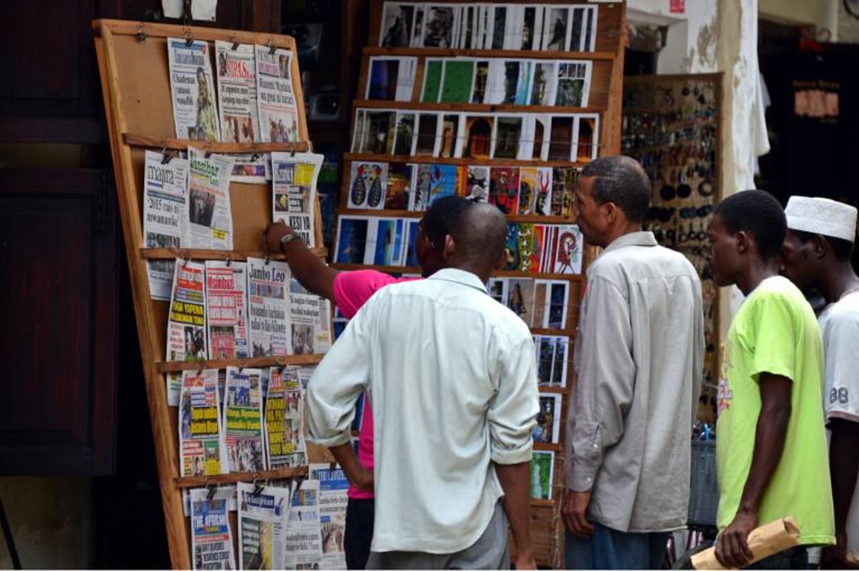 Des personnes regardent des journaux, le 7 janvier 2013 à Stone Town, à Zanzibar, en Tanzanie. © AFP/GABRIEL BOUYS