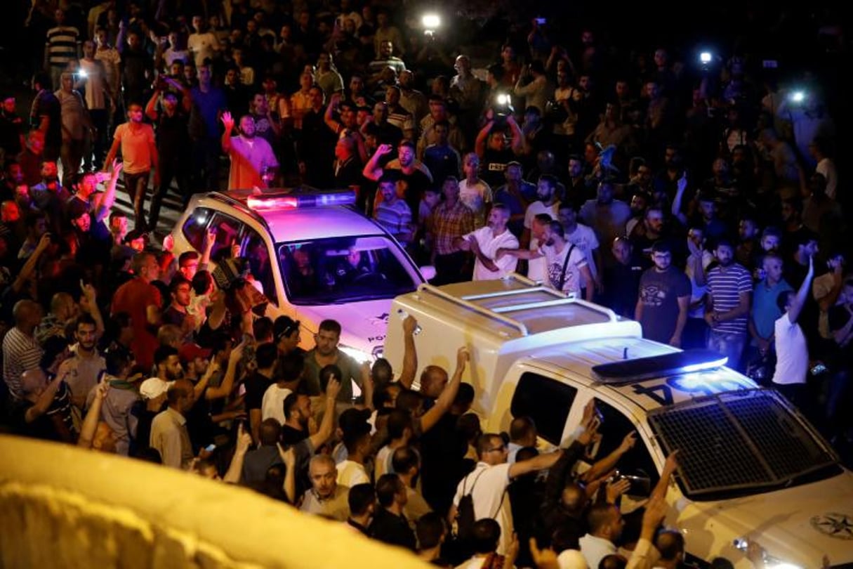 Des manifestants palestiniens tentent de bloquer le passage des voitures de la police israélienne, à Jérusalem, le 22 juillet 2017. © Ahmad Gharabli / AFP