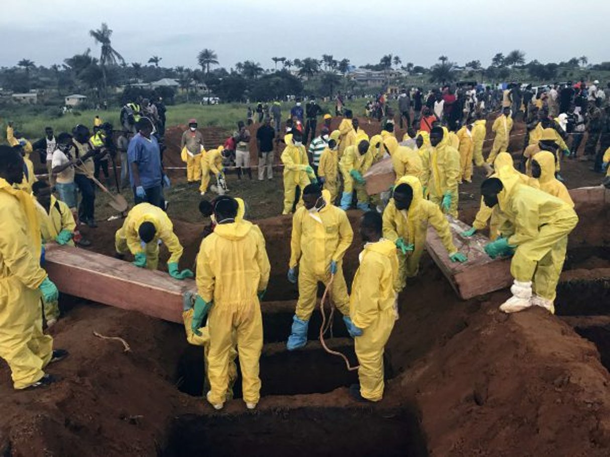 Des volontaires aident à enterrer les corps des victimes des inondations survenues à Freetown, la capitale sierra-léonaise, en août 2017. © Manika Kamara/AP/SIPA